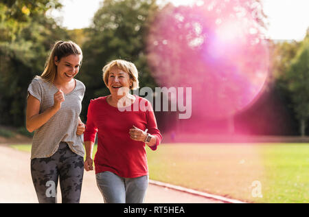 Petite-fille et grand-mère s'amuser, faire du jogging ensemble dans le parc Banque D'Images