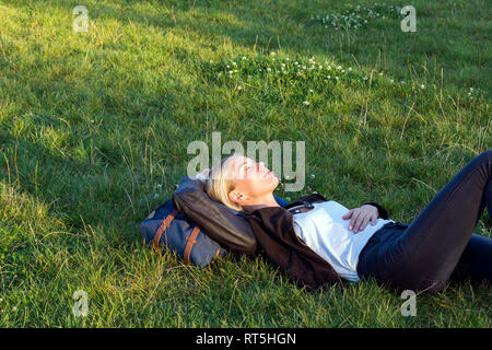 Femme couchée sur un pré de détente dans un parc Banque D'Images