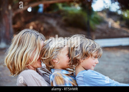 Heureuse fête avec deux fils assis dans une rangée à l'extérieur Banque D'Images