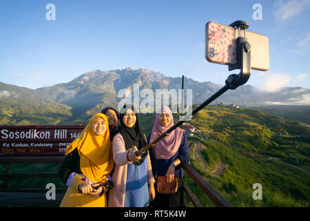 Kundasang Sabah Malaisie - Dec 28, 2019 : Groupe de femmes musulmanes en tenant à l'aide de selfies smartphone à Kudasang Sabah.Kundasang a highland à Bornéo est pop Banque D'Images