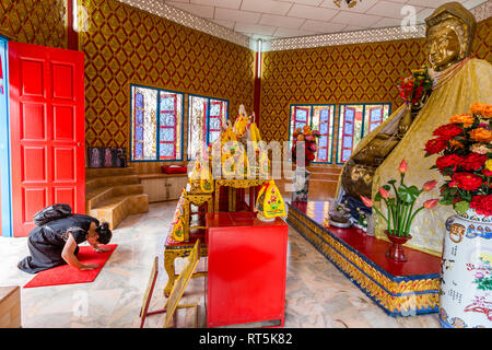 Adorateur priant à statue bouddhiste à culte à côté de Wat Chayamangkalaram Temple, du Bouddha couché. George Town, Penang, Malaisie Banque D'Images