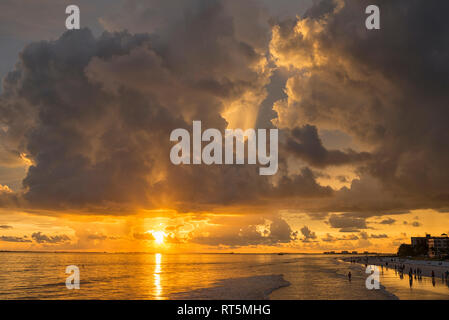 États-unis d'Amérique, Floride, Fort Myers, silhouettes de Fort Myers Beach et les touristes avec un énorme nuage de pluie au-dessus pendant le coucher du soleil Banque D'Images