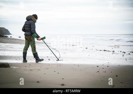 Homme avec détecteur de métal à la plage de sable Banque D'Images