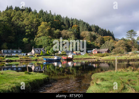 Les bateaux de pêche amarrés devant les maisons à Waterfoot près du village de Carradale sur la péninsule de Kintyre sur un après-midi ensoleillé. Banque D'Images