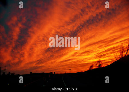 Voiture allume la chaussée dans la superbe paysage crépuscule coucher du soleil dans le beau paysage de soleil rose flou Banque D'Images