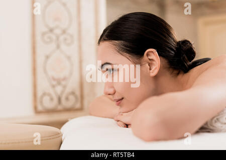 Profil de beautiful Asian woman lying on massage table et détente au spa Banque D'Images