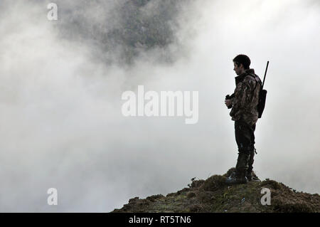 Hunter à la recherche de gibier, comme le chamois, le chevreuil ou tahr, en Afrique du Westland Alpes du Sud, Nouvelle-Zélande Banque D'Images