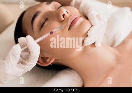 Close up of attractive asian woman getting injection à la Clinique de beauté Banque D'Images