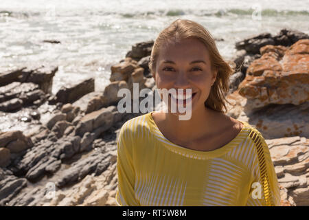 Woman relaxing on the rock at beach Banque D'Images