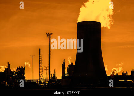 Industrial Estate montrant tour de refroidissement découpé sur coucher de soleil sur le site de production chimique BASF dans le port d'Anvers, Belgique Banque D'Images