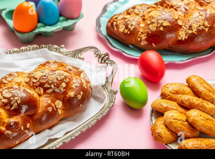 Œufs de Pâques et tsoureki tresse, pain sucré de Pâques grecque, sur un fond de couleur rose Banque D'Images