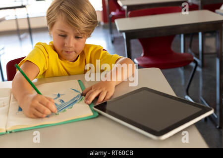 Boy drawing esquisse sur pc portable à 24 dans une salle de classe Banque D'Images