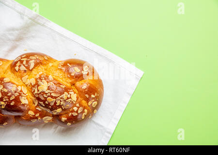 La préparation de Pâques. Tsoureki tresse, pain sucré de Pâques grecque sur nappe blanche, couleur vert, l'arrière-plan Vue de dessus, copy space Banque D'Images