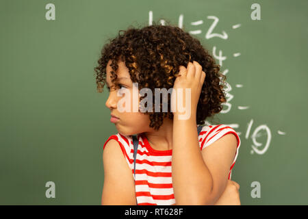 Lycéenne contre permanent conseil vert dans une salle de classe à l'école Banque D'Images