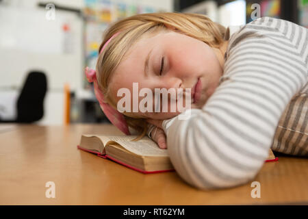 Lycéenne dormir sur livre à 24 dans la salle de classe Banque D'Images