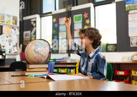 Levant la main d'écolier à 24 dans la salle de classe Banque D'Images