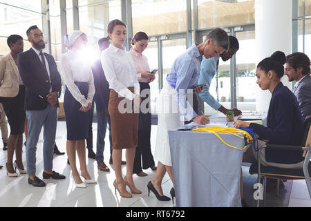 Young en signature à l'inscription à la conférence tableau Banque D'Images