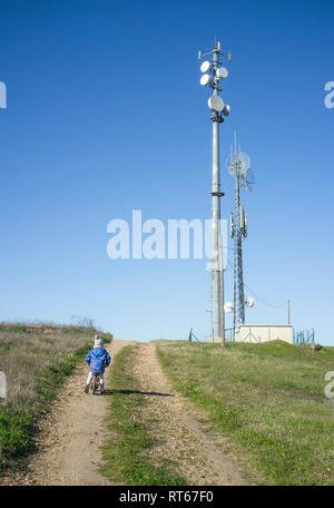 Garçon enfant de se trouver si près de l'antenne mobile. Rayonnement des téléphones mobiles pour les enfants concept Banque D'Images