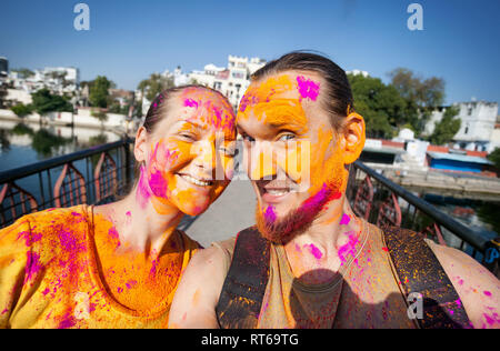 Photo selfies tourist couple avec visage peint célébrant le festival haut en couleurs de Holi dans la rue d'Udaipur, Rajasthan, Inde Banque D'Images