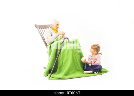 Vieille Femme assis sur le fauteuil à bascule avec ses petits-enfants Banque D'Images