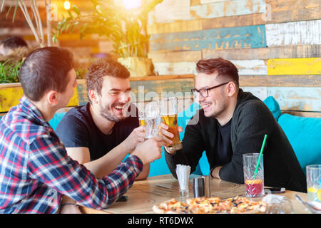 Trois jeunes hommes aime boire de la bière au pub branché Banque D'Images