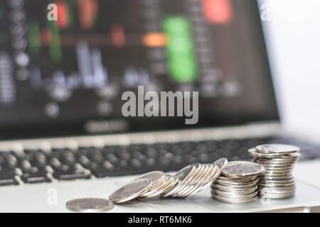 Pièce en argent avec le moniteur affiche le trafic commercial, Bitcoin minning, coin colapse en face de l'ordinateur portable moniteur. transaction en ligne concept Banque D'Images