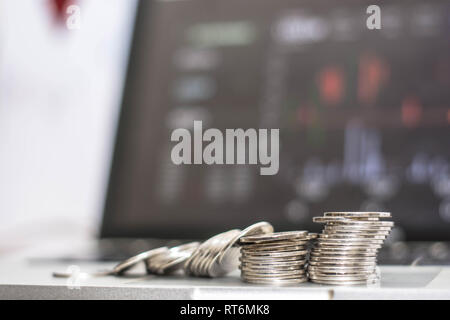 Pièce en argent avec le moniteur affiche le trafic commercial, Bitcoin minning, coin colapse en face de l'ordinateur portable moniteur. transaction en ligne concept Banque D'Images