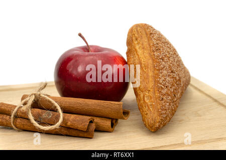 Pâte feuilletée maison chaussons aux pommes, pomme et cannelle sur une planche à découper en bois isolé sur fond blanc Banque D'Images