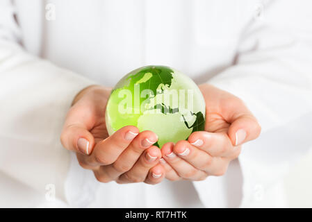 Globe en verre vert dans la main Banque D'Images
