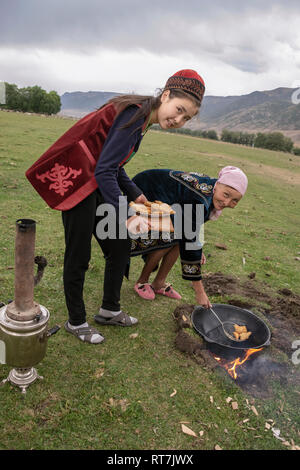 La femme baursaki kazakh de friture dans un wok au dessus d'une flamme, retournerais sans hésiter, Kazakhstan Banque D'Images