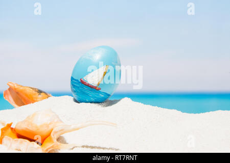 Pâques sur fond de plage tropicale. Des œufs sur le sable blanc. Locations et travel concept au printemps Banque D'Images