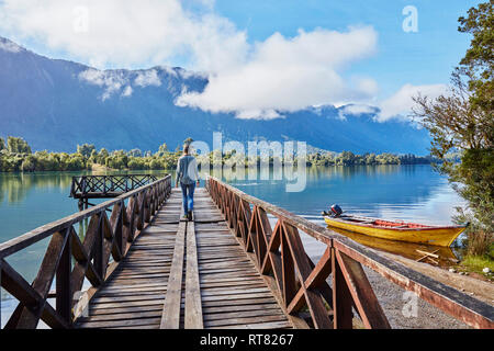 Chili, Lago Rosselot, Chaiten, woman walking on jetty Banque D'Images