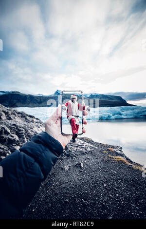 L'Islande, l'homme déguisé en Père Noël qui sort d'un téléphone cellulaire Banque D'Images