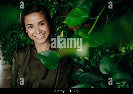 Le portrait de jeune femme au mur avec plantes grimpantes Banque D'Images