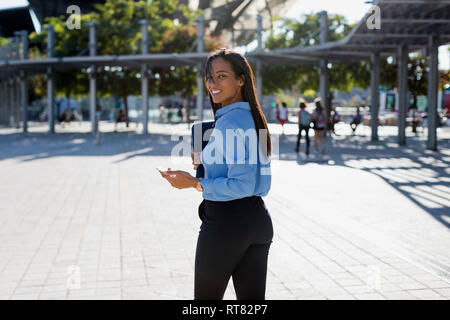 Businesswoman with smartphone, sac d'ordinateur portable Banque D'Images