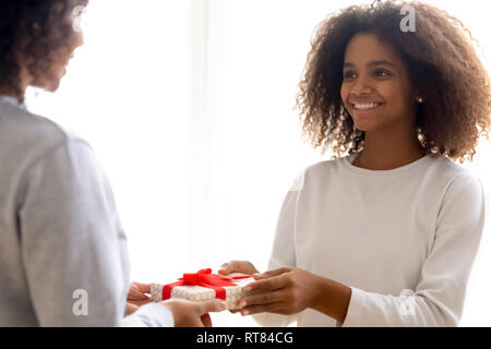 Happy mixed race fille donnant à présent Mère bien-aimée Banque D'Images