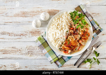 Fricassée de poulet sur une plaque avec de la viande de poulet - riz doré et mijotée dans du vin blanc, sauce crème aux champignons et légumes, classic fr Banque D'Images