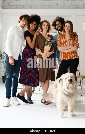 Photo de groupe avec un chien, d'amis, célébrer ghe anniversaire et une jeune femme Banque D'Images