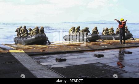 Marines avec la Compagnie Alpha, l'Équipe de débarquement du bataillon, 1er Bataillon, 4ème Marines, attendre pour lancer leurs razzias en caoutchouc de combat à bord de l'artisanat landing ship dock USS Ashland (LSD 48), mer des Philippines, le 25 janvier 2019. BLT 1/4 est l'élément de combat au sol pour la 31e Marine Expeditionary Unit. La 31e MEU, le Marine Corps' seulement continuellement de l'avant-MEU déployée en partenariat avec Wasp ARG, fournit une force meurtrière et flexible prêt à réaliser une vaste gamme d'opérations militaires comme la première force d'intervention de crise dans la région Indo-Pacifique. Banque D'Images