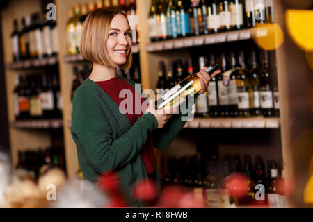 Photo de femme heureuse avec bouteille dans ses mains Banque D'Images