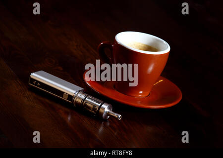 E-cigarette à côté d'une tasse de café. Expression de (moderne) plaisir et de détente. Banque D'Images