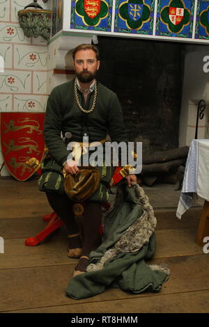 Un homme bien habillé Tudor en face d'une grande cheminée à la Tour de Londres Banque D'Images