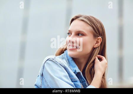 Une blonde happy girl smiles dans un style urbain. Banque D'Images