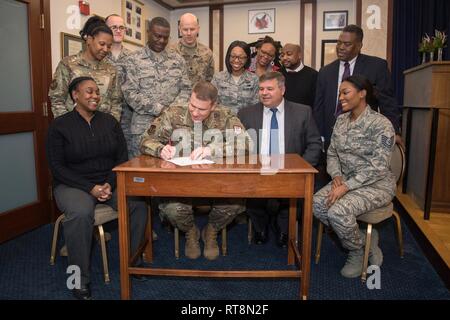 Le colonel Tchad Ellsworth, commandant du centre, l'installation, signe une proclamation du Mois de l'histoire afro-américaine à Hanscom Air Force Base, Mass., le 28 janvier, tandis que Jacquelynn Coles, assis à gauche, Tech. Le Sgt. Mackyeon Tina, debout de gauche à droite, le s.. Garrett Guidinger, chef Master Sgt. Henry Hayes, chef du commandement de l'installation, le Lieutenant-colonel Kenneth Ferland, 66th Air Base Group commandant adjoint du lieutenant Nijha, Londres, Stéphanie Lafitte, Thomas Fredericks, assis, Chris Roach, Galen Williams, Tech. Le Sgt. DeShierra Tweggs, assis à droite, les membres du comité AAHM, regard sur. Tout au long du mois de février, le Han Banque D'Images