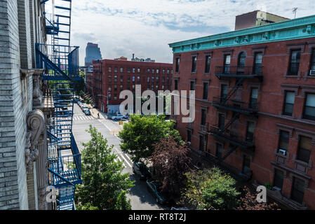 Sommaire d'une rue avec ses vieilles maisons typiques et les gens autour dans le quartier de Harlem à Manhattan, New York City, USA Banque D'Images