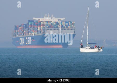 Le navire à très gros conteneurs de 400 mètres, CMA CGM LOUIS BLERIOT, quitte le port de Southampton, UN petit bateau à voile dans le parc forestier. ROYAUME-UNI. Banque D'Images