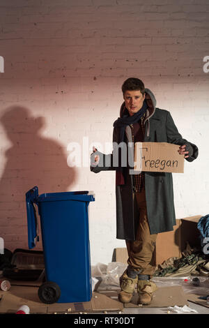 Homeless man showing ok sign et la tenue de la carte en carton avec l'inscription "freegan" Banque D'Images