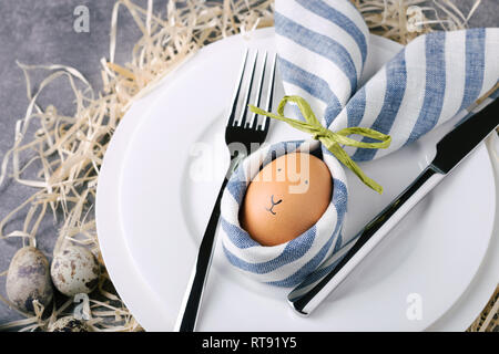 Belle table de Pâques avec des œufs en serviette Lapin de Pâques. Vue de dessus, gros plan. Banque D'Images