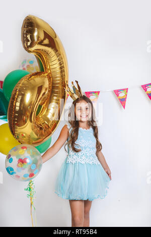 Belle petite princesse en robe bleue avec des ballons. Anniversaire pour enfant mignon. Banque D'Images