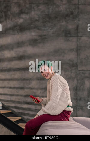 Woman wearing oversized beige pull et pantalon brillant Banque D'Images